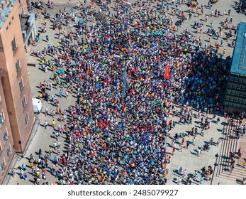 High angle shot capturing a large crowd of runners in diverse attire during the Riga Marathon 2024, showcasing the vibrant energy of the event in Riga, Latvia.