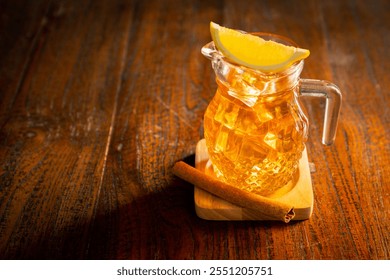 High angle shot of cold lemon tea with ice cubes and lemon wedge, sits on the coaster with cinnamon stick - Powered by Shutterstock