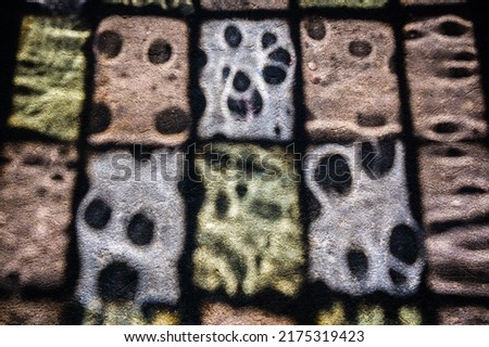 A high angle shot of a colorful window glass shadow on the ground