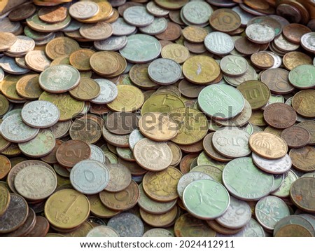 A high angle shot of different-sized coins in a bunch