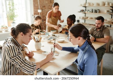 High angle shot of diverse group of people decorating ceramics in pottery workshop, copy space - Powered by Shutterstock