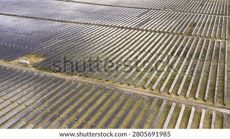High angle shot of expansive solar panel rows in a rural Australian landscape.