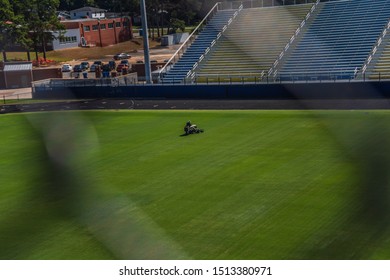 High Angle Shot Of A Football Field With A Man Mowing On A Reel Mower