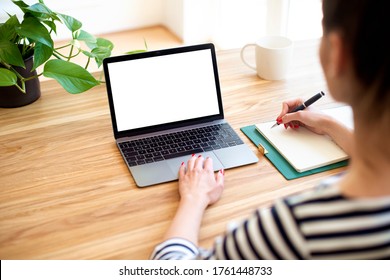 High angle shot of businesswoman’s hand while typing on notebook on the desk. Notebook with blank screen. 