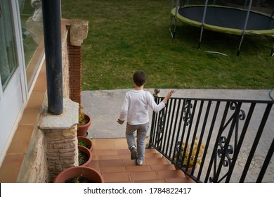 A high angle shot of a little boy going downstairs to play outside