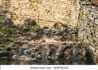 A High Angle Shot Of A Man Made Pond At The Corner Of A Stone Wall In An Animal Sanctuary