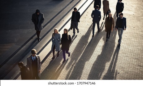 High Angle Shot Of Office Managers And Business People Commuting To Work In The Morning Or From Office On A Sunny Day On Foot. Pedestrians Are Dressed Smartly. Successful People Holding Smartphones.