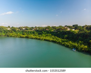 A high angle shot of a pond by a beautiful green shore under the blue sky captured in Mombasa, Kenya