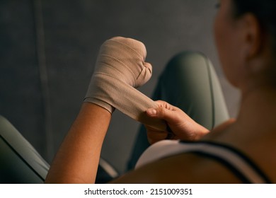 High angle shot of professional boxer wrapping her hands with elastic bandage