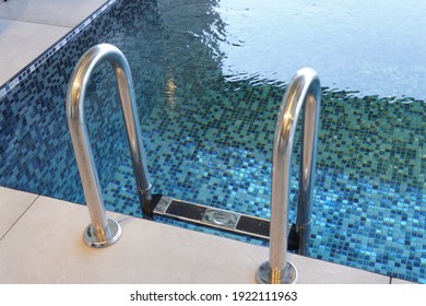 A High Angle Shot Of A Stainless Steel Ladder On A Swimming Poo