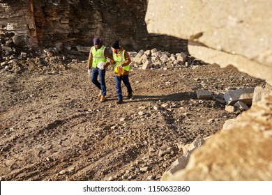 High Angle Shot Of Two Industrial  Workers Wearing Reflective Jackets Walking In Dirt On Mining Worksite Outdoors, Copy Space