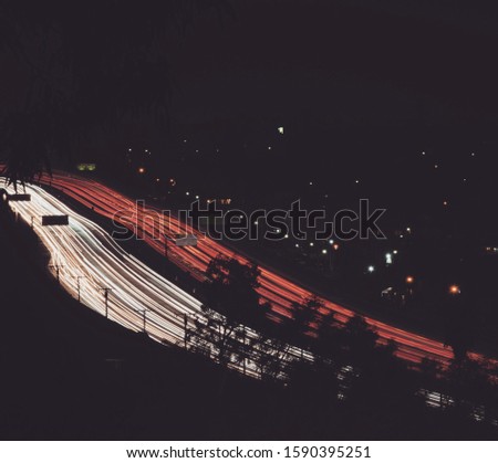 A high angle shot of two parallel highways with red and white lights at night