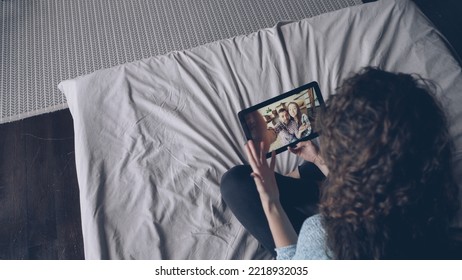 High Angle Shot Of Young Girl Making Video Call Using Tablet And Talking To Friends Online Discussing News. Young Woman Is Speaking, Gesturing And Showing Thumbs-up Holding Gadget.