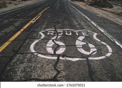 High Angle Of Sign Of Route 66 On Asphalt Empty Road Going Through Dry Desert In Sunny Day In America