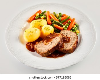 High Angle Still Life Of Hearty Dinner Meal - Slices Of Meatloaf With Brown Gravy, Roasted Potatoes, And Mixed Vegetables Served In White Dish On White Background