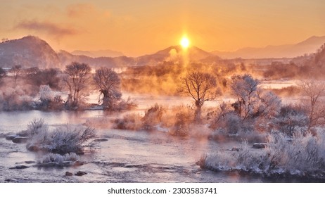 High angle and sunrise view of hoarfrost on the tree with water fog on Namhan River in winter at Mokgye-ri near Chungju-si, South Korea
					