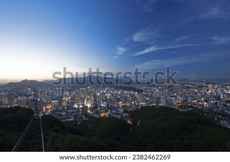 High angle and sunset view of cable cars against high rise buildings with light at Namsan Mountain near Jung-gu, Seoul, South Korea
