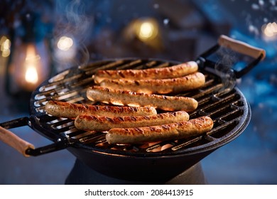 High Angle Of Tasty Appetizing Grilled Sausages On Metal Lattice Cooking On Backyard On Winter Night