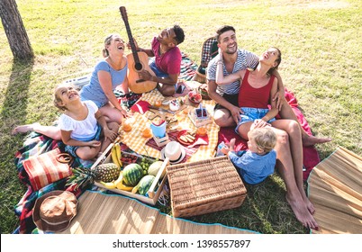 High angle top view of happy families having fun with kids at pic nic barbecue party - Multiracial love concept with mixed race people playing with children at public park - Warm retro vintage filter