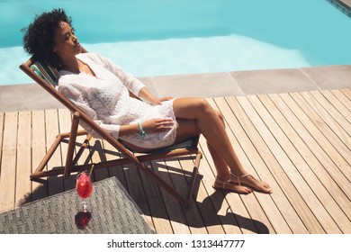 High Angle View Of African American Woman Relaxing On Sun Lounger In Her Backyard On A Sunny Day