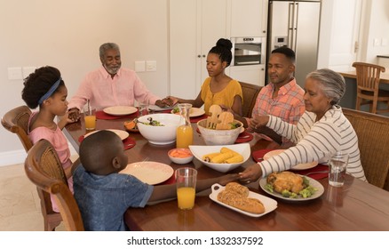 High angle view of an African American multi-generation family holding their hands and praying together before having meal on dining table at home