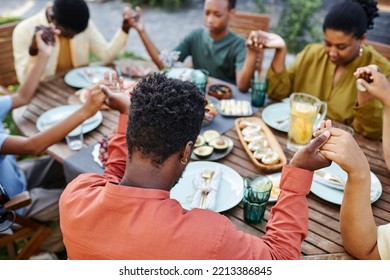 High Angle View At African American Family Saying Grace At Table Outdoors And Holding Hands During Gathering