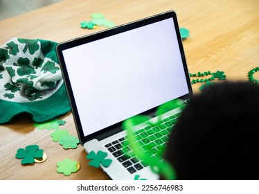 High angle view of african american man on video call through laptop with copy space. unaltered, people, lifestyle, technology and st patrick's day celebration concept. - Powered by Shutterstock