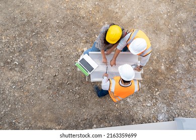 High angle view of architect and engineer meeting planning for a new project about detail of building at construction site.