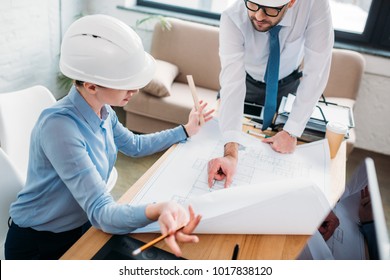 high angle view of architects working with building plan at office