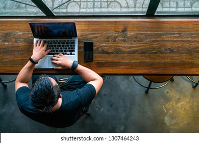 High Angle View Of Asian Man Using The Laptop