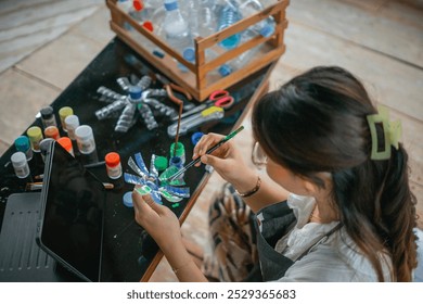 high angle view of asian woman making recycled plastic bottle handcraft - Powered by Shutterstock