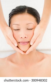 High angle view of an attractive young woman receiving facial massage at spa center Foto Stok