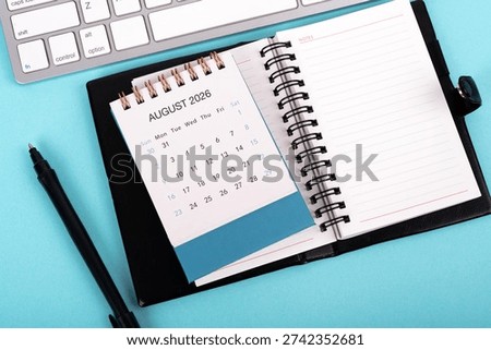 High angle view of August 2026 desk calendar and notepad
