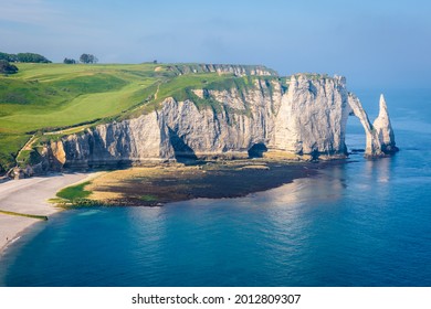 High angle view of the Aval cliff in Etretat, Normandy, with the Needle and the arch on a sunny spring morning.