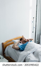 High Angle View Of Awake Patient Stretching On Hospital Bed