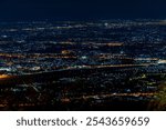 High angle view background from the mountain, showing the lights of apartment buildings, houses, car lights and street lights, the advancement of technology and electricity lighting at night.