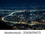 High angle view background from the mountain, showing the lights of apartment buildings, houses, car lights and street lights, the advancement of technology and electricity lighting at night.