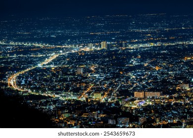 High angle view background from the mountain, showing the lights of apartment buildings, houses, car lights and street lights, the advancement of technology and electricity lighting at night. - Powered by Shutterstock