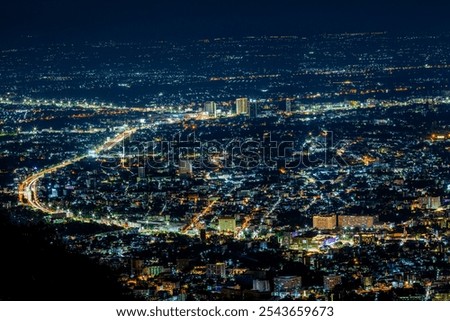 High angle view background from the mountain, showing the lights of apartment buildings, houses, car lights and street lights, the advancement of technology and electricity lighting at night.