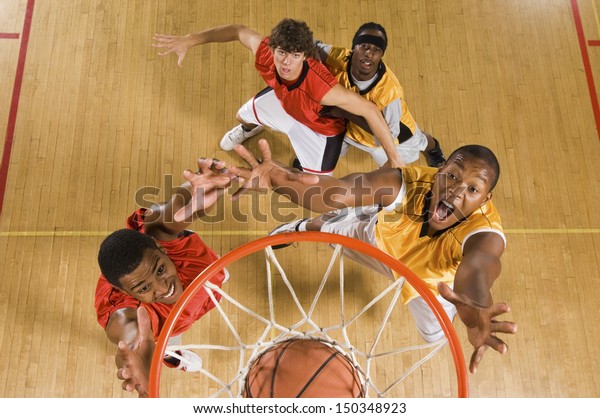 バスケットボールの選手がフープでバスケットボールをダンキングする高い角度のビュー の写真素材 今すぐ編集