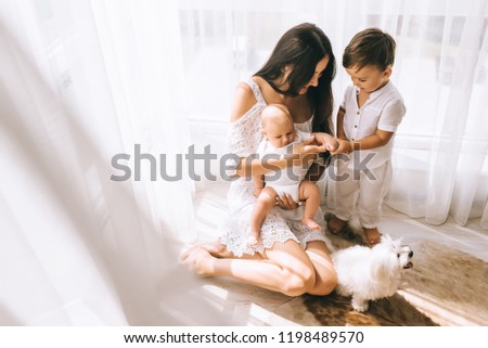 Relaxed mother and sons playing over the bed