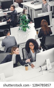 high angle view of beautiful smiling young multiethnic businesswomen using desktop computer in office 