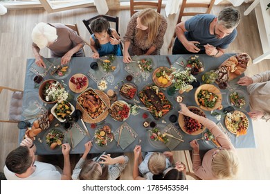 High Angle View Of Big Family Sitting At The Table And Having Dinner Together At Home