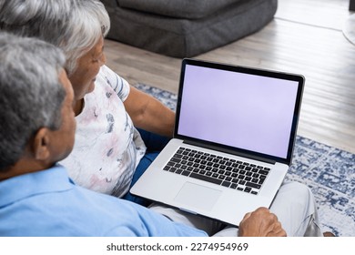 High angle view of biracial senior couple using laptop while relaxing on sofa in living room. Copy space, unaltered, love, together, retirement, screen, home, technology and lifestyle concept. - Powered by Shutterstock