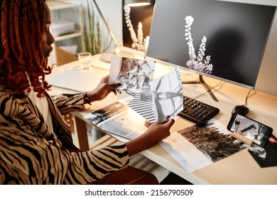 High Angle View At Black Female Creator Holding Photographs While Choosing One For Publishing, Copy Space