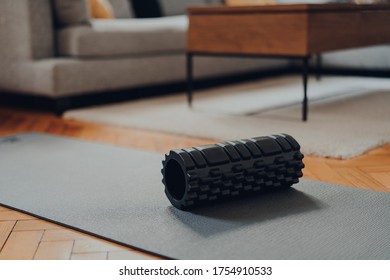 High Angle View Of Black Foam Roller And A Fitness Mat Within Modern Living Space, Selective Shallow Focus. 