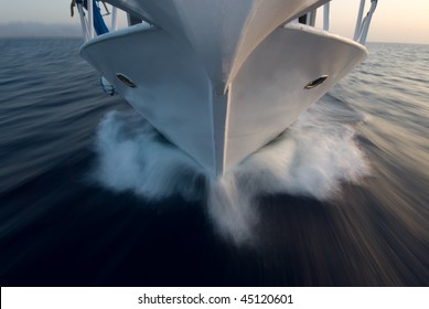 High angle view of the bow of a small motor boat moving over the surface of a flat sea.