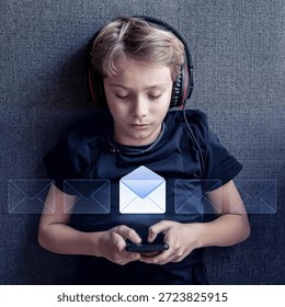 High Angle View Of Boy Lying On Sofa Using Smartphone With Glowing Email Message Icon Overlay