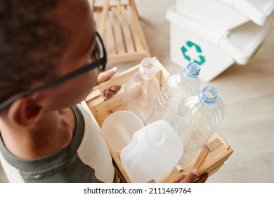 High angle view of boy sorting household waste at home and carrying plastic bottles, copy space - Powered by Shutterstock