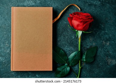 high angle view of a brown book, with the Catalan flag, and a red rose for Sant Jordi, the Catalan name for Saint George Day, when it is tradition to give red roses and books in Catalonia, Spain